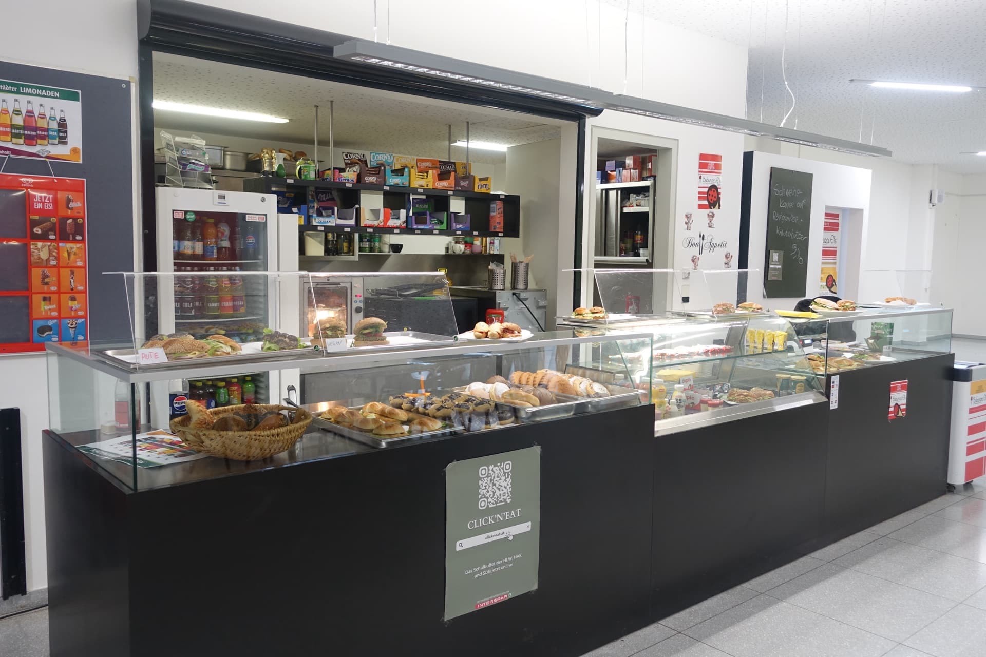 Die Theke des Schulbuffets mit belegten Weckerln, Gebäck, Snacks und Getränken in den Vitrinen.